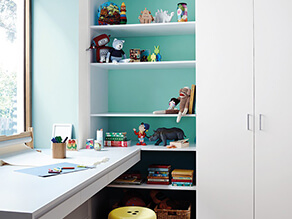Childrens_study_area_blue_painted_feature_wall_white_hidden_shelf_dinosaur_toys_desk_yellow_stool